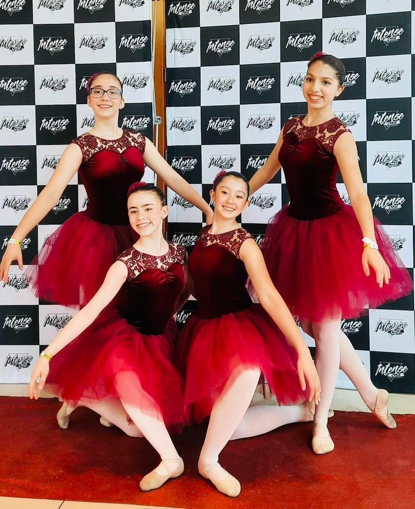 Cuatro alumnas con tutús rojos antes de salir a escena